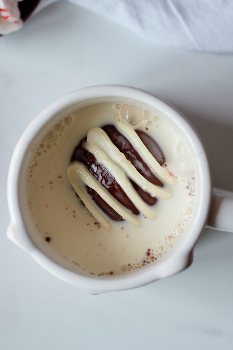 top down view of a mug filled with a chocolate bomb and milk
