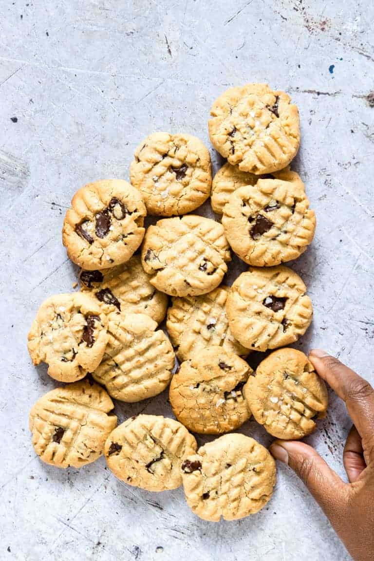 a hand taking some vegan peanut butter chocolate chip cookies 