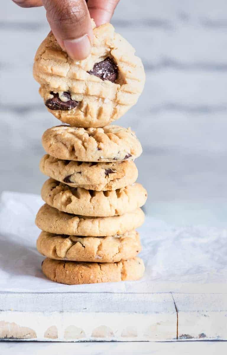 Gluten-free Peanut Butter Cookies in a stack, with one being taken up