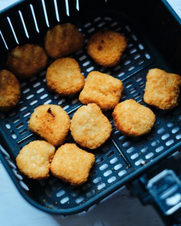 top down view of the frozen chicken nuggets inside the air fryer basket