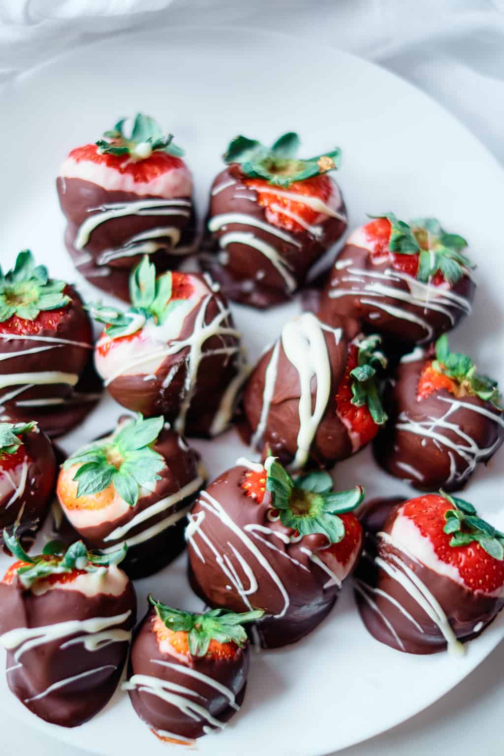 top down view of the finished chocolate coated strawberries served on a white plate