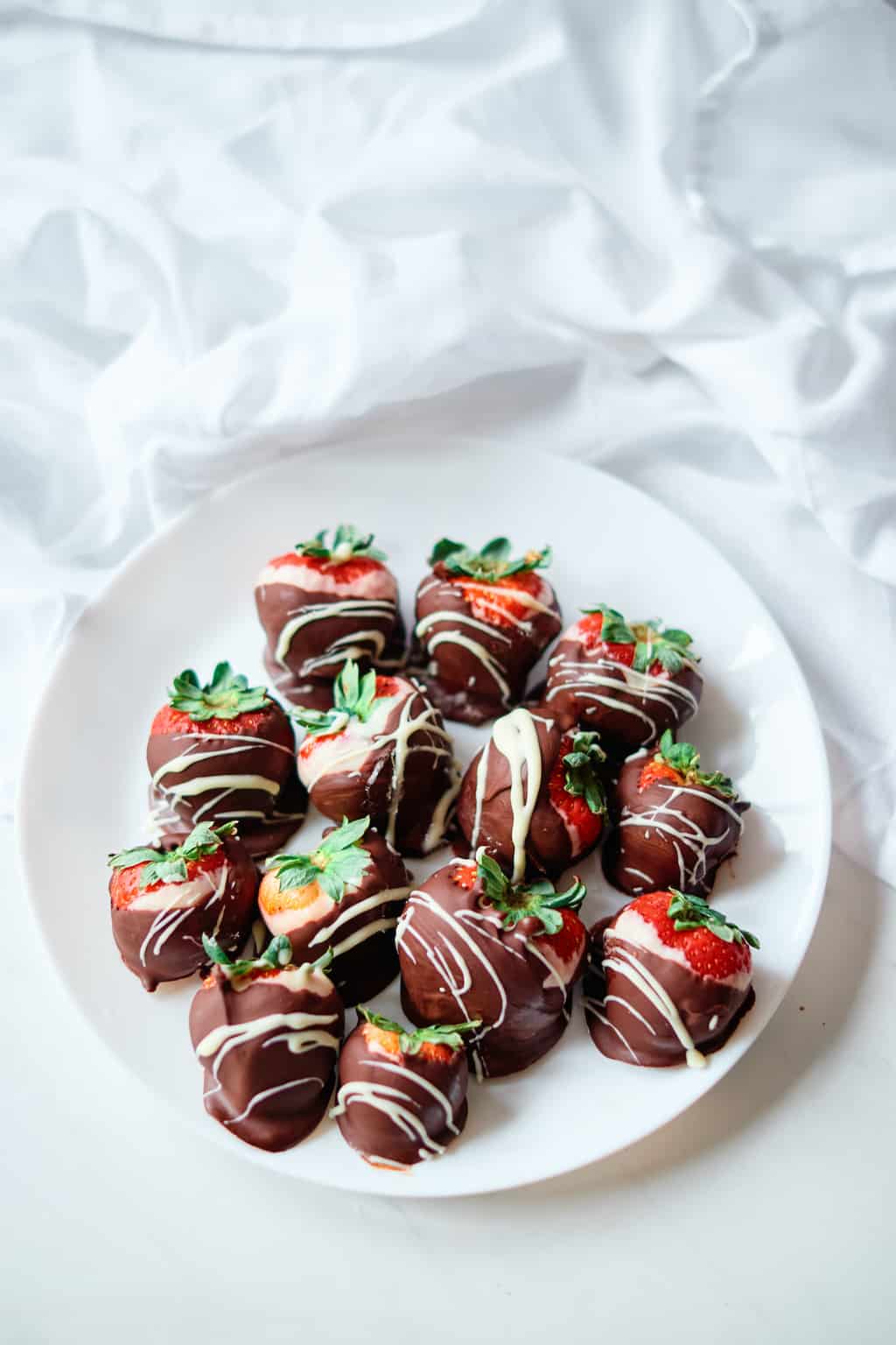 a plate filled with chocolate covered strawberries