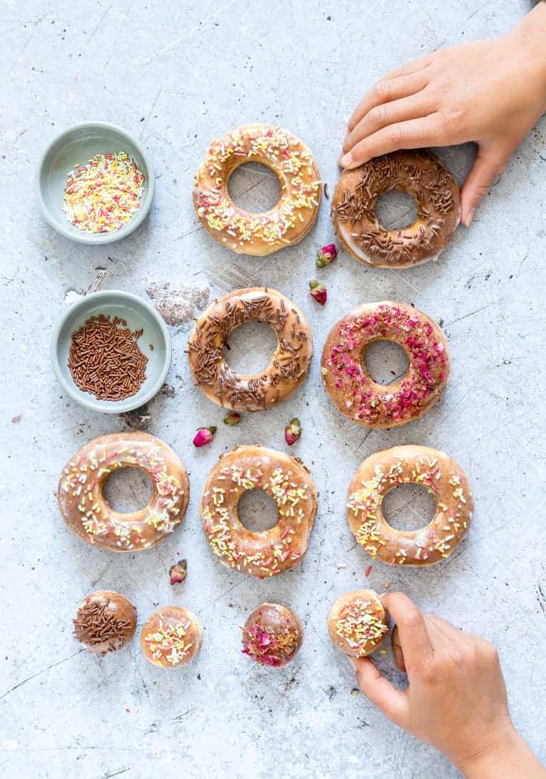 hands reaching for air fryer donuts with sprinkles