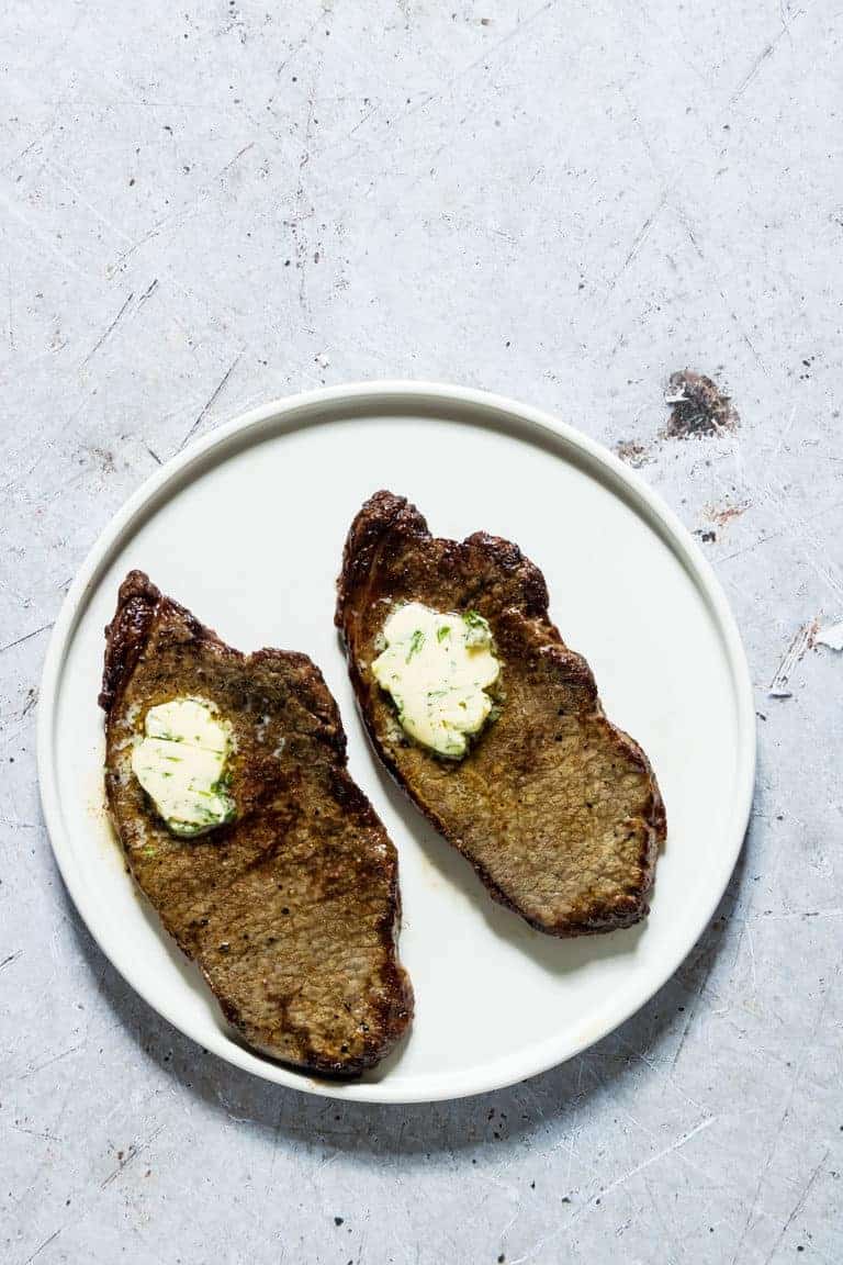 2 air fryer steaks on a plate with butter