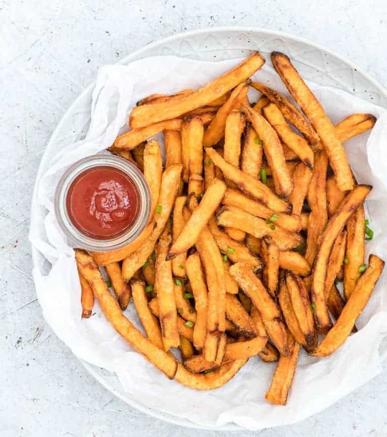 close up view of a plate with Air Fryer Sweet Potato Fries and a side of ketchup