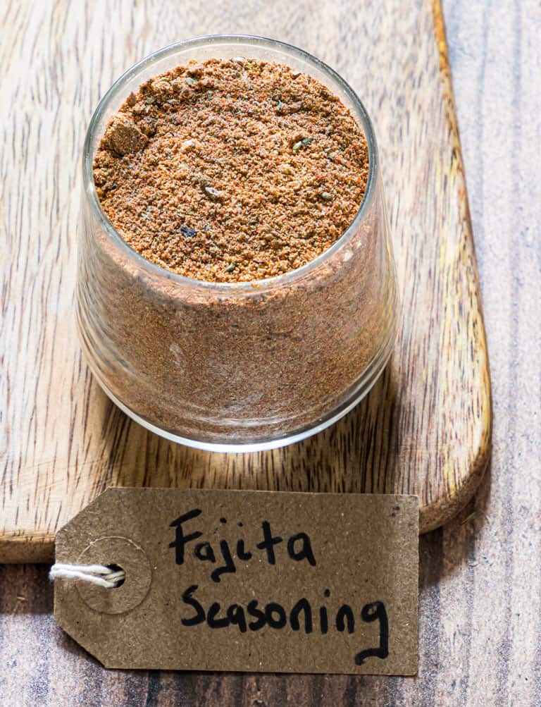 the completed fajita seasoning recipe in a jar with a handwritten label in front
