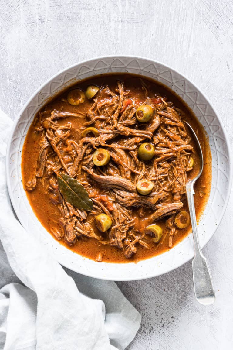 a bowl of pressure cooker ropa vieja served with a silver spoon