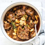 Jamaican Oxtail Stew in a white serving bowl with spoon