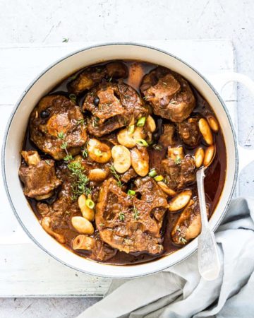 Jamaican Oxtail Stew in a white serving bowl with spoon