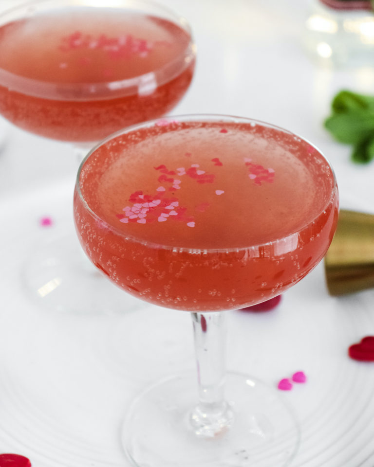 the completed rose spritzer cocktail served in two champagne glasses