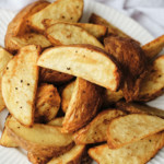 close up view of the completed air fryer potato wedges served on a white plate