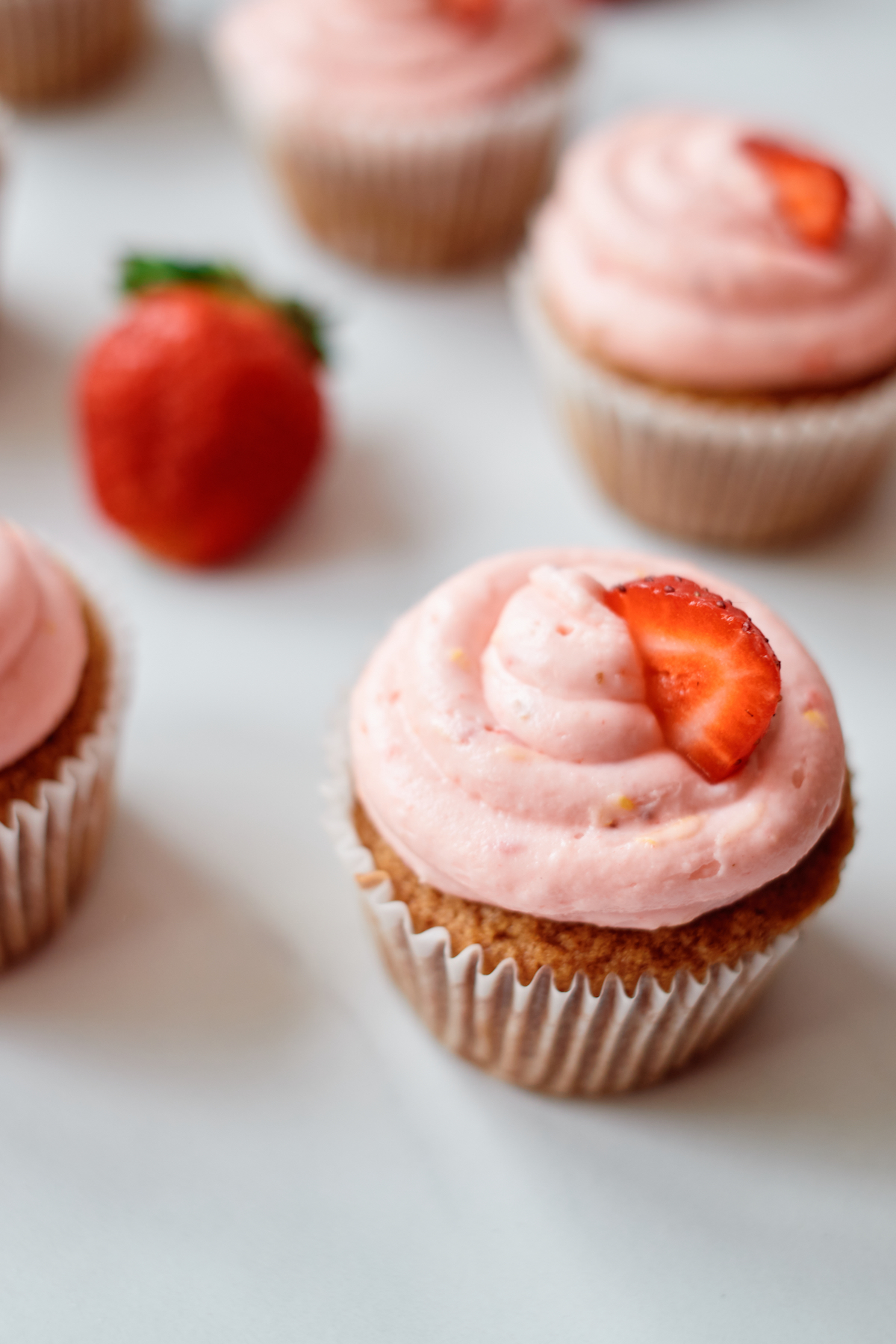 the finished strawberry cupcakes with churro flavors lined up on a countertop