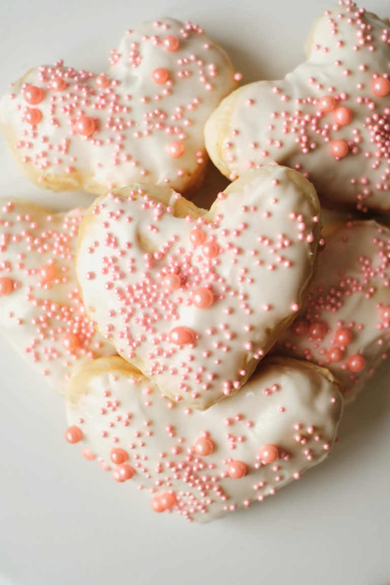 top down view of the completed valentines donuts piled onto a white plate