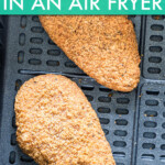 two fried chicken pieces in an air fryer basket