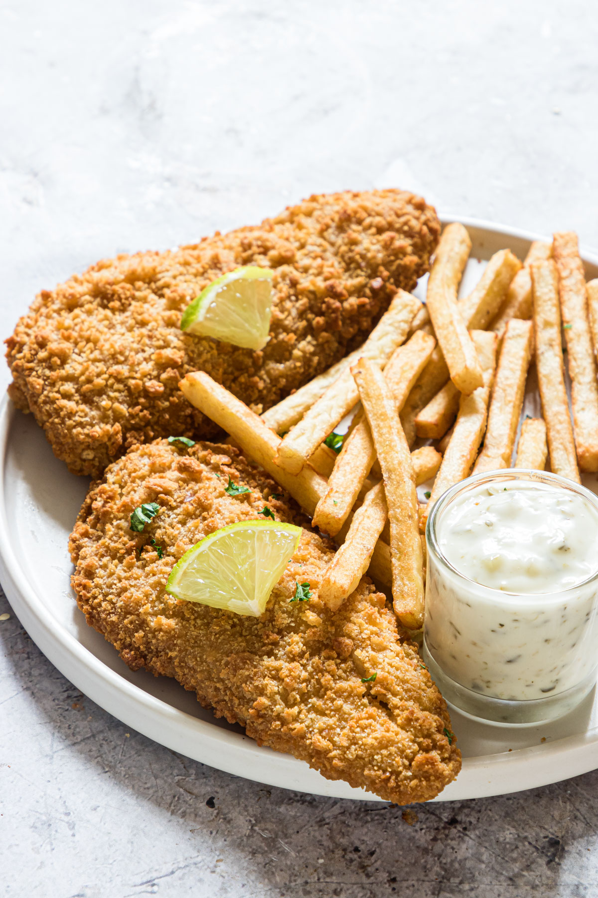 the cooked air fryer frozen fish fillets served with tartar sauce and french fries