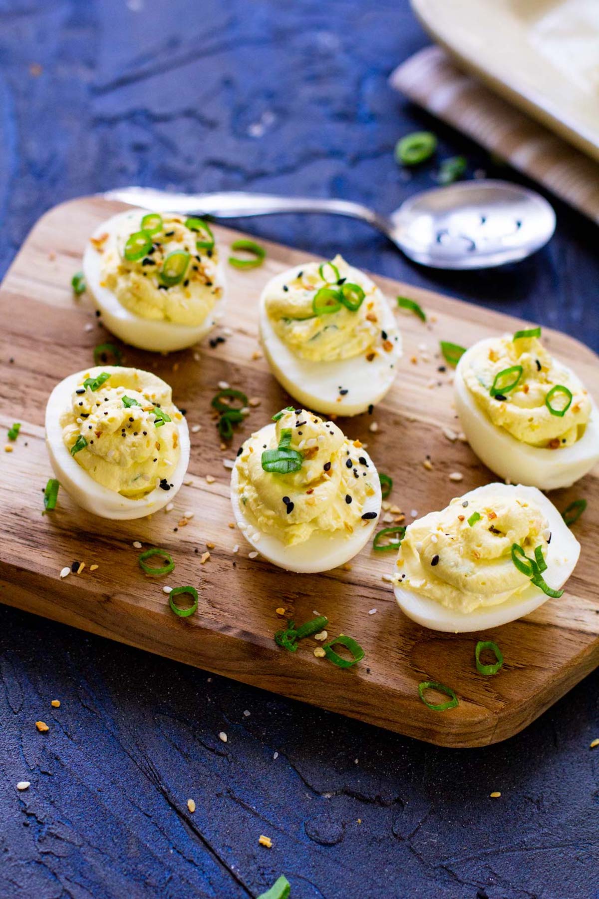 six completed instant pot deviled eggs on a wooden serving board