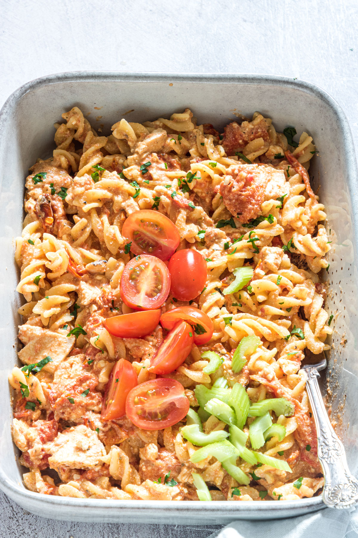 the completed buffalo chicken baked feta pasta topped with cherry tomatoes and diced celery