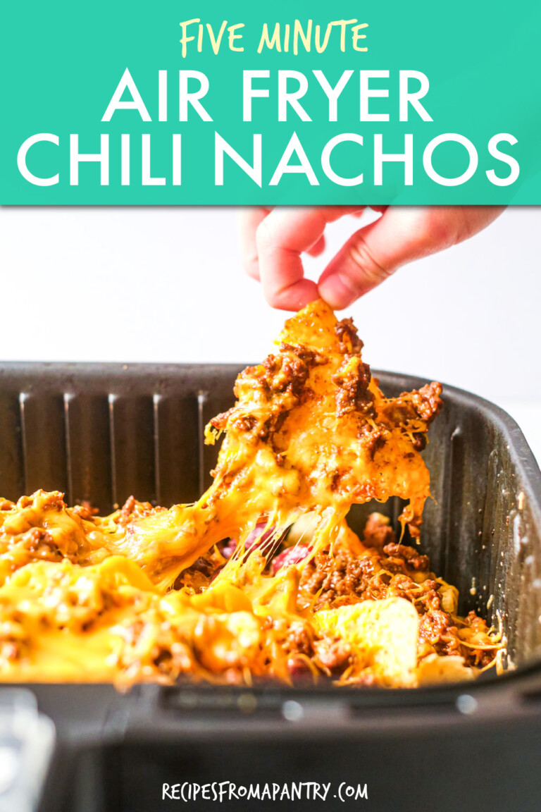 A child's hand pulling cheesy nachos out of an air fryer basket