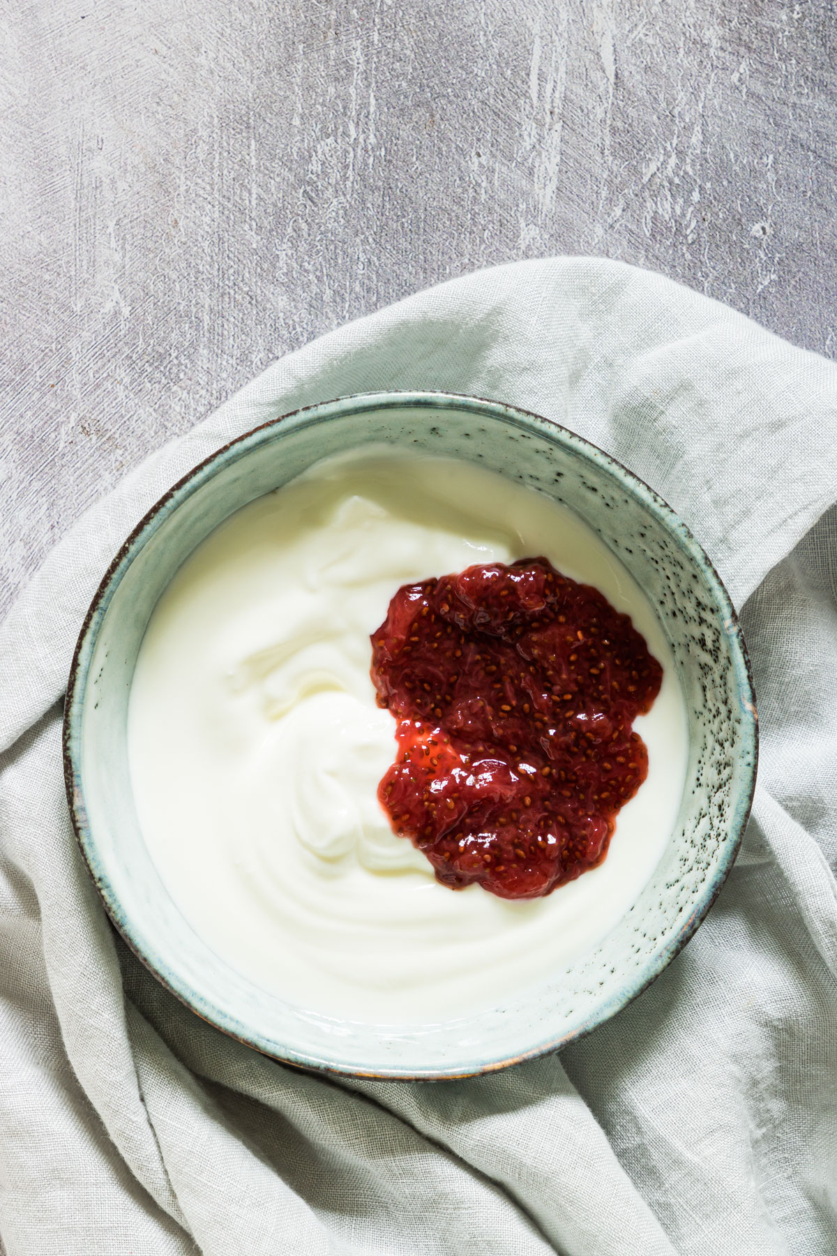 a bowl of yogurt with jam on a table