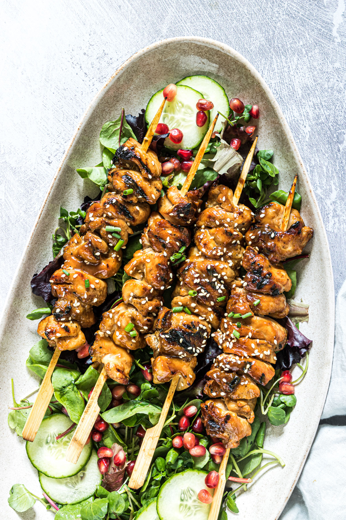 grilled chicken skewers on a bed of lettuce and ready to be served