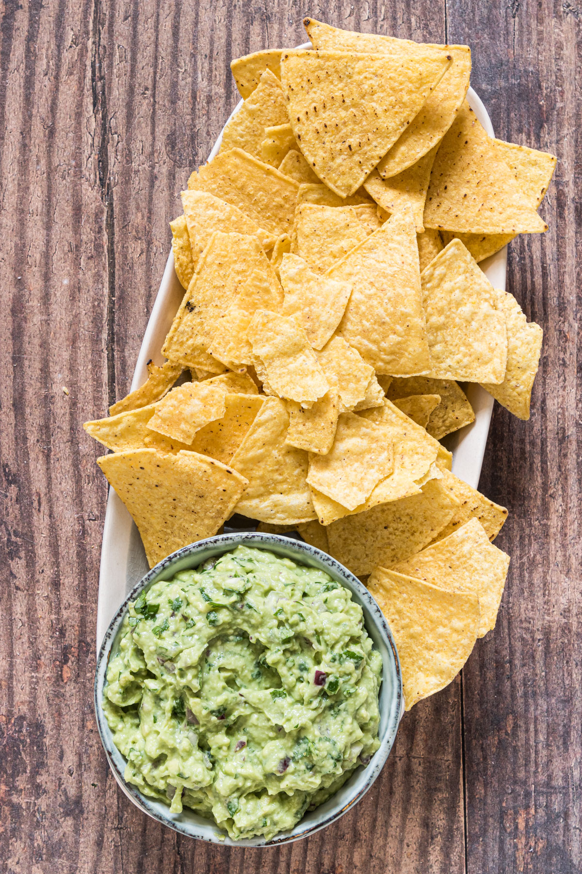 a platter with homemade guacamole and tortilla chips