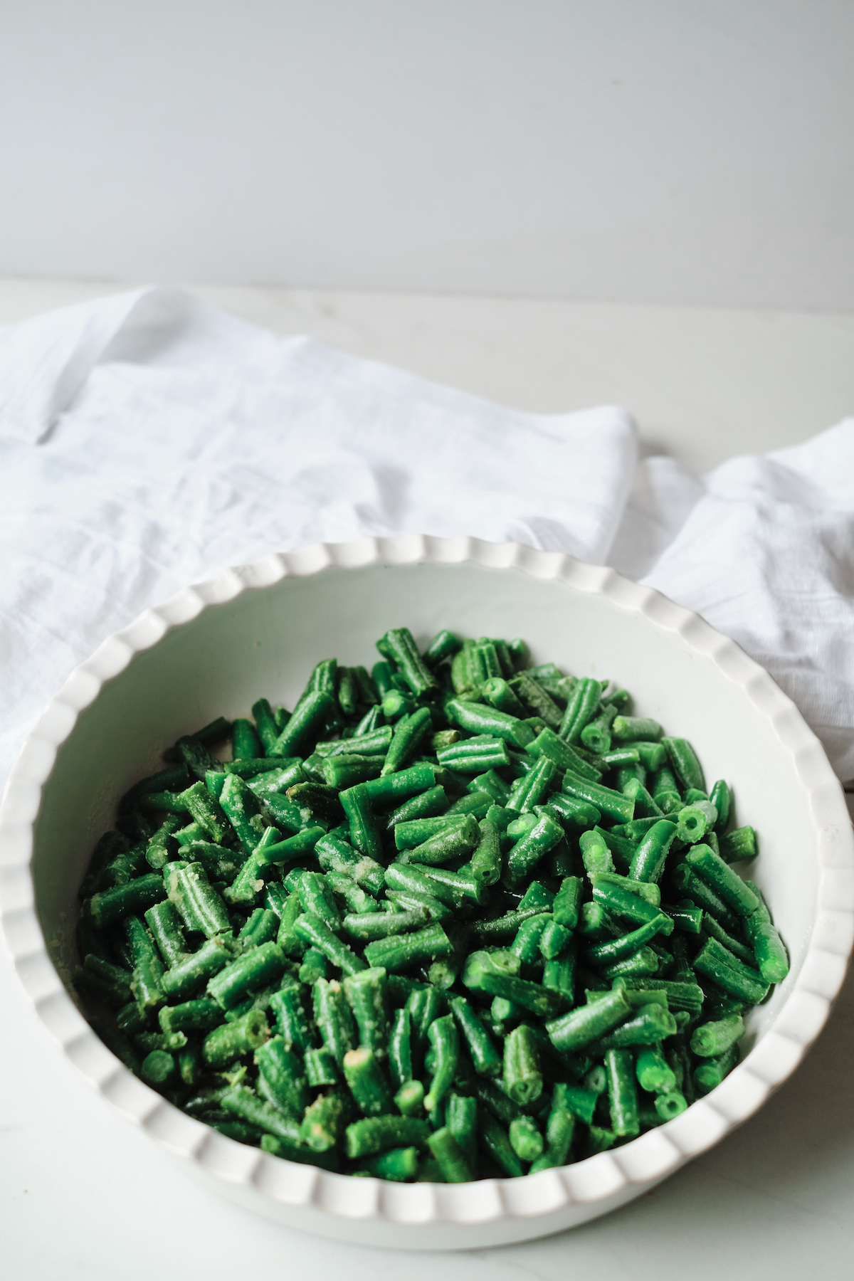 the cooked green beans served in a white dish after completing air fryer frozen vegetables recipe