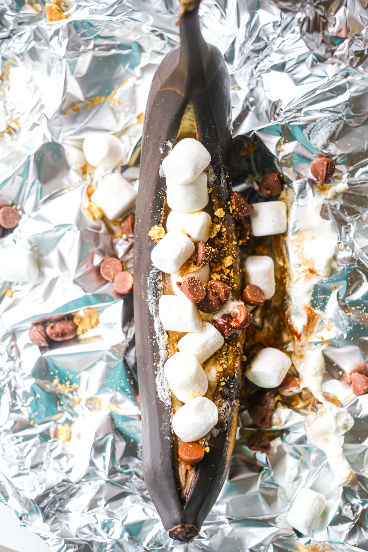 a smores banana split that has been cooked on the campfire