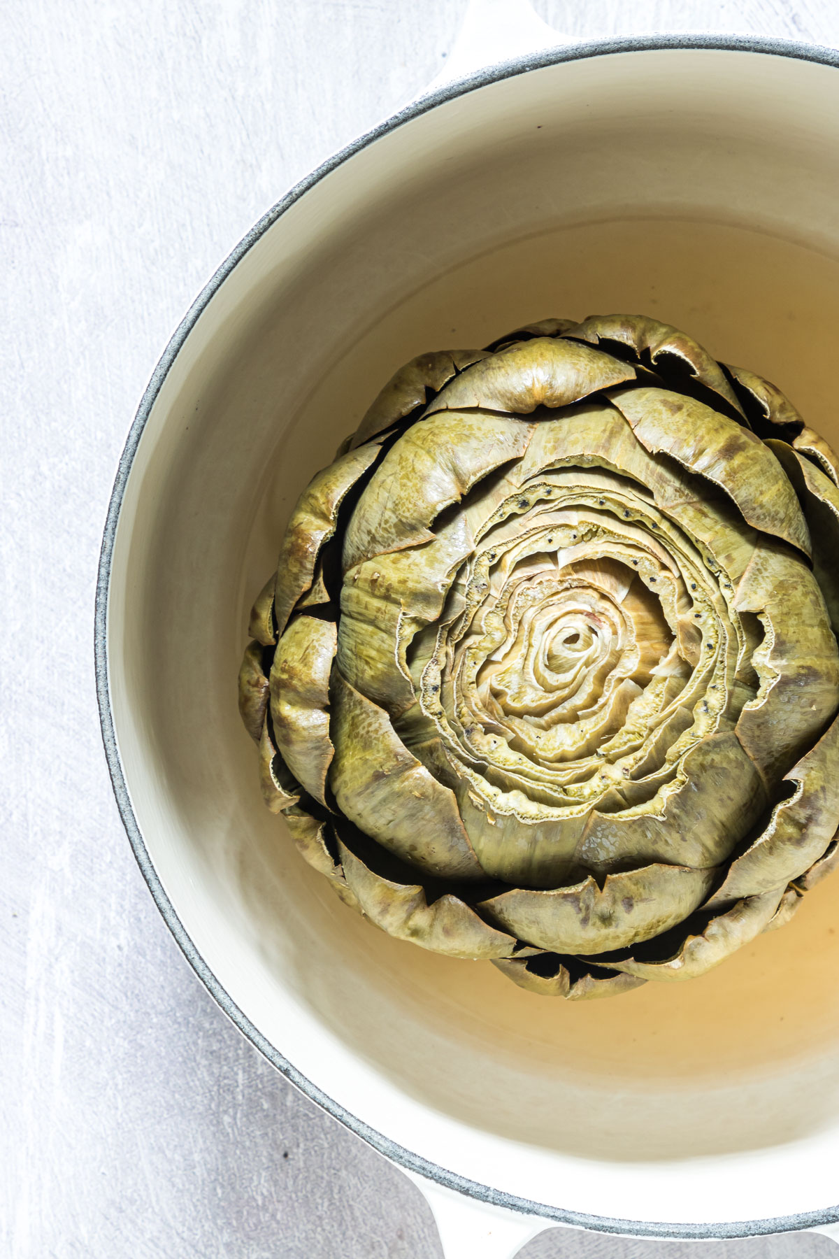 close up view of a cooked artichoke ready to be served