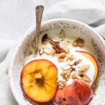 a bowl containing grilled peaches with walnuts and ice cream