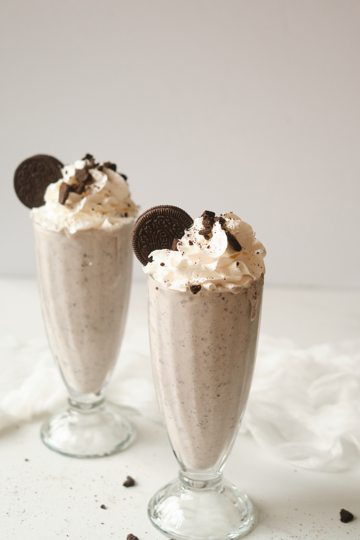 two glasses filled with oreo cookie milkshake