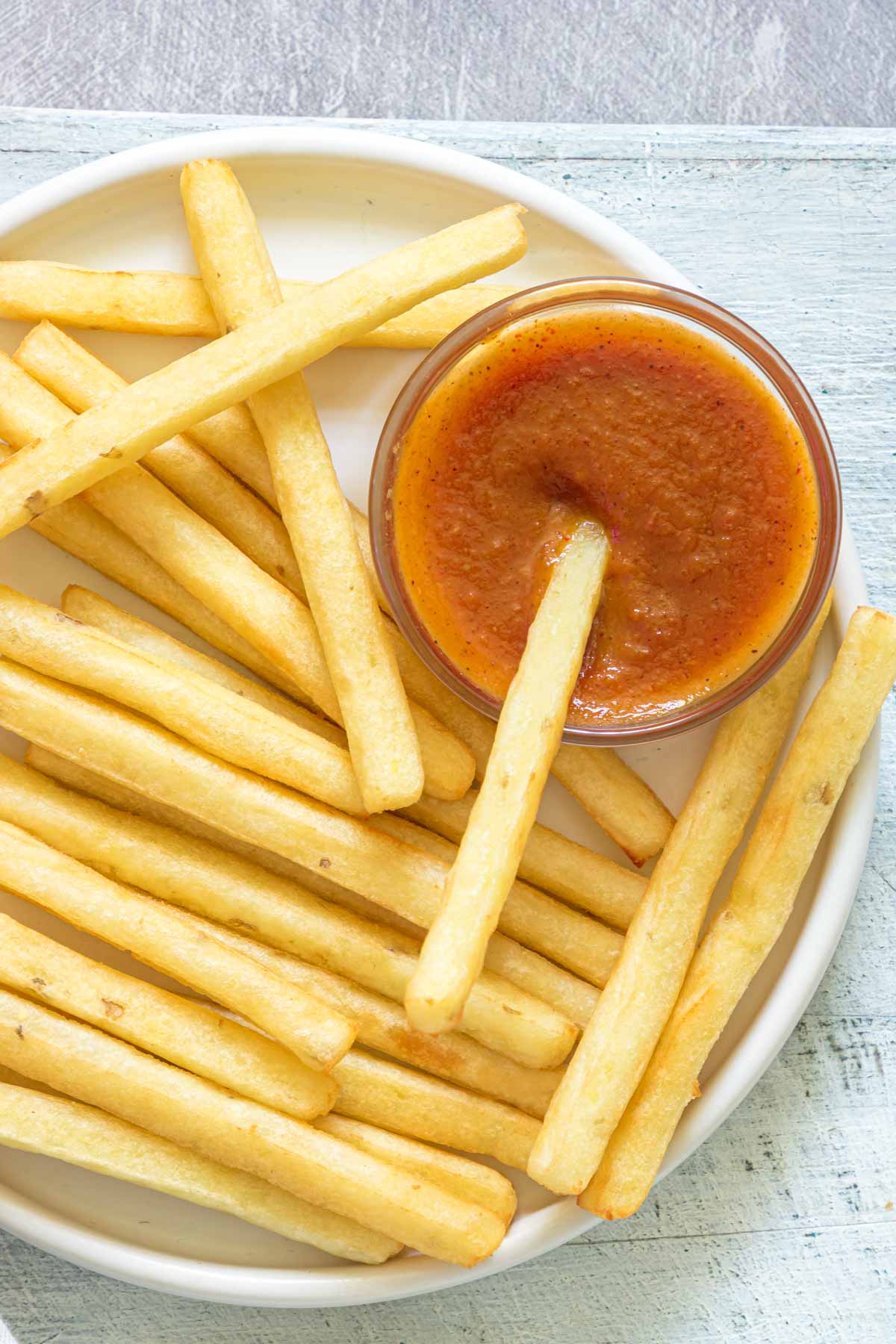 homemade ketchup in serving bowl, with some fries on a plate