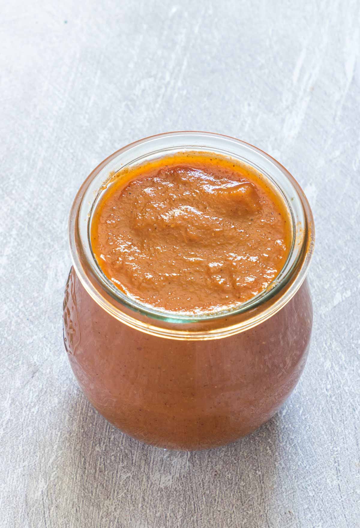 homemade ketchup - homemade tomato ketchup in a glass jar on a table
