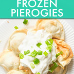 pierogies on a plate topped with sour cream and chopped scallion