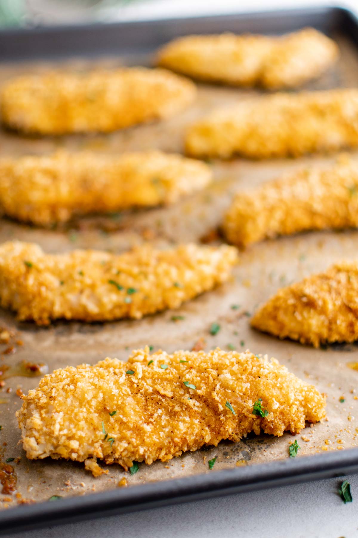 close up view of the baked chicken tenders on a baking tray