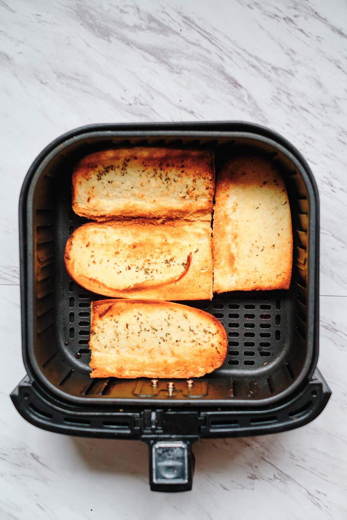 top down view of the cooked frozen garlic bread in air fryer basket