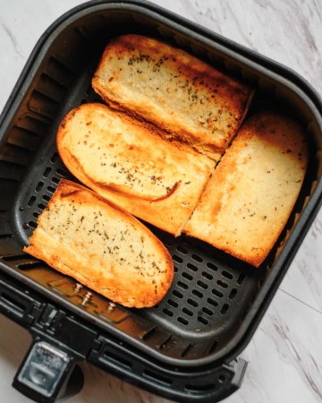 top down view of the frozen garlic bread in air fryer basket cooked and ready to be served