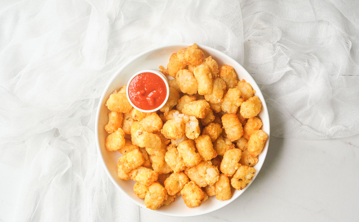 top down view of the air fryer frozen tater tots in a serving bowl