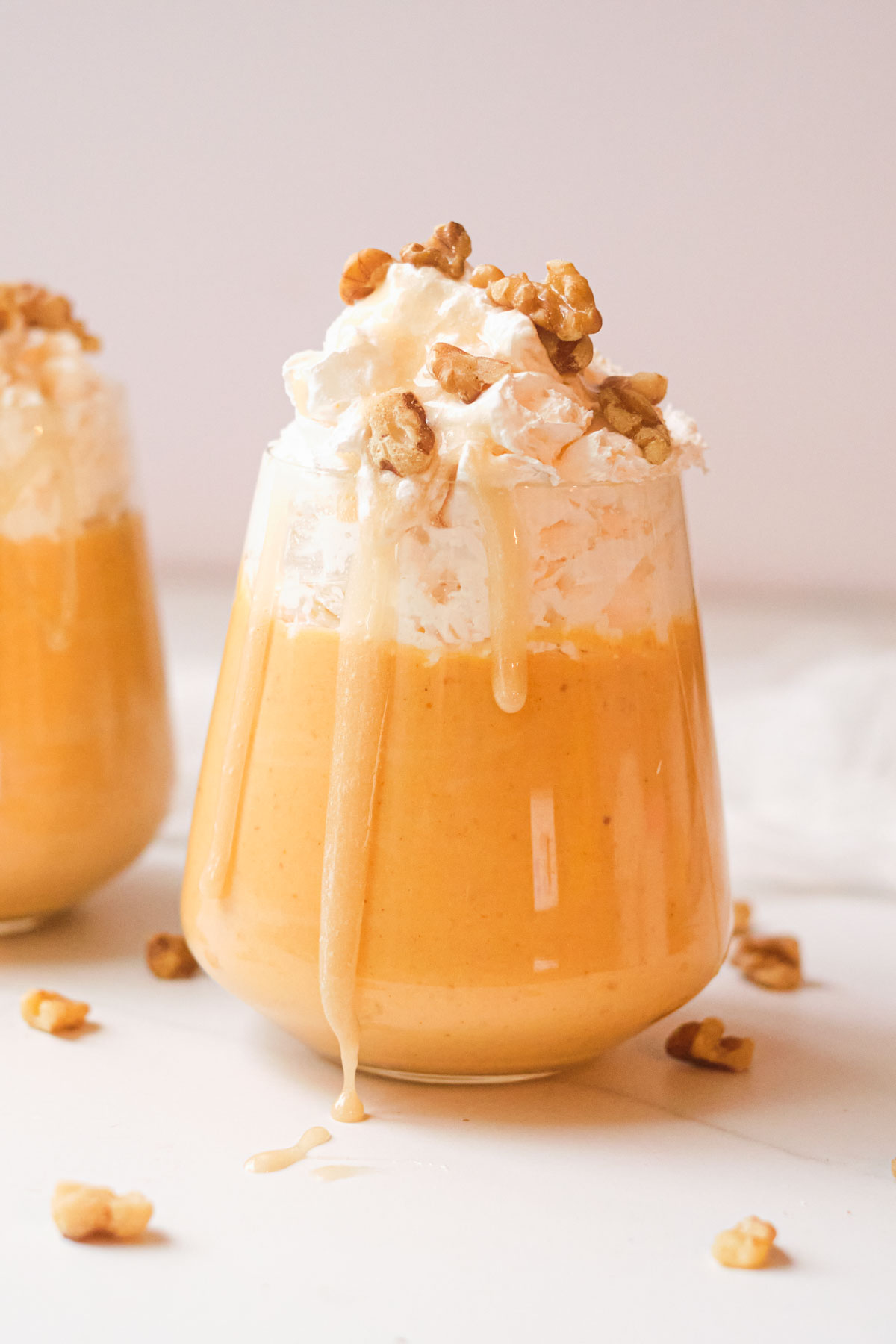 the finished pumpkin smoothie topped with whipped cream and nuts