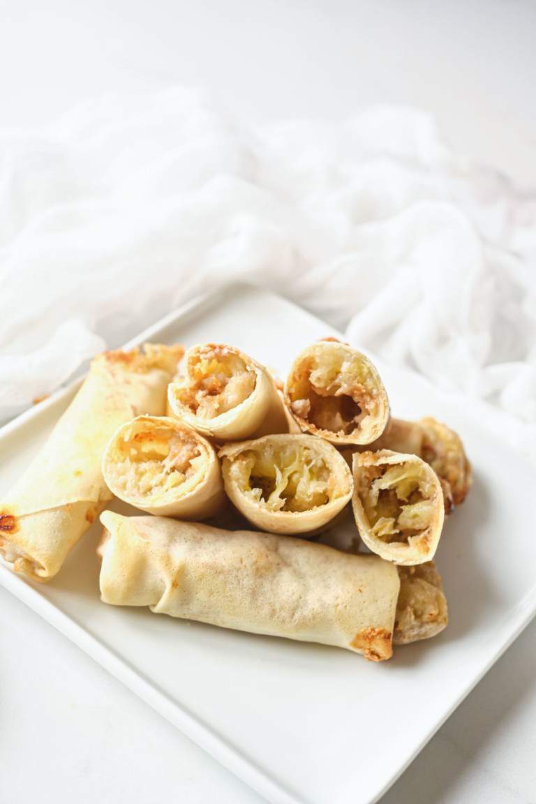 the finished air fryer peanut butter banana spring rolls served on a white square plate