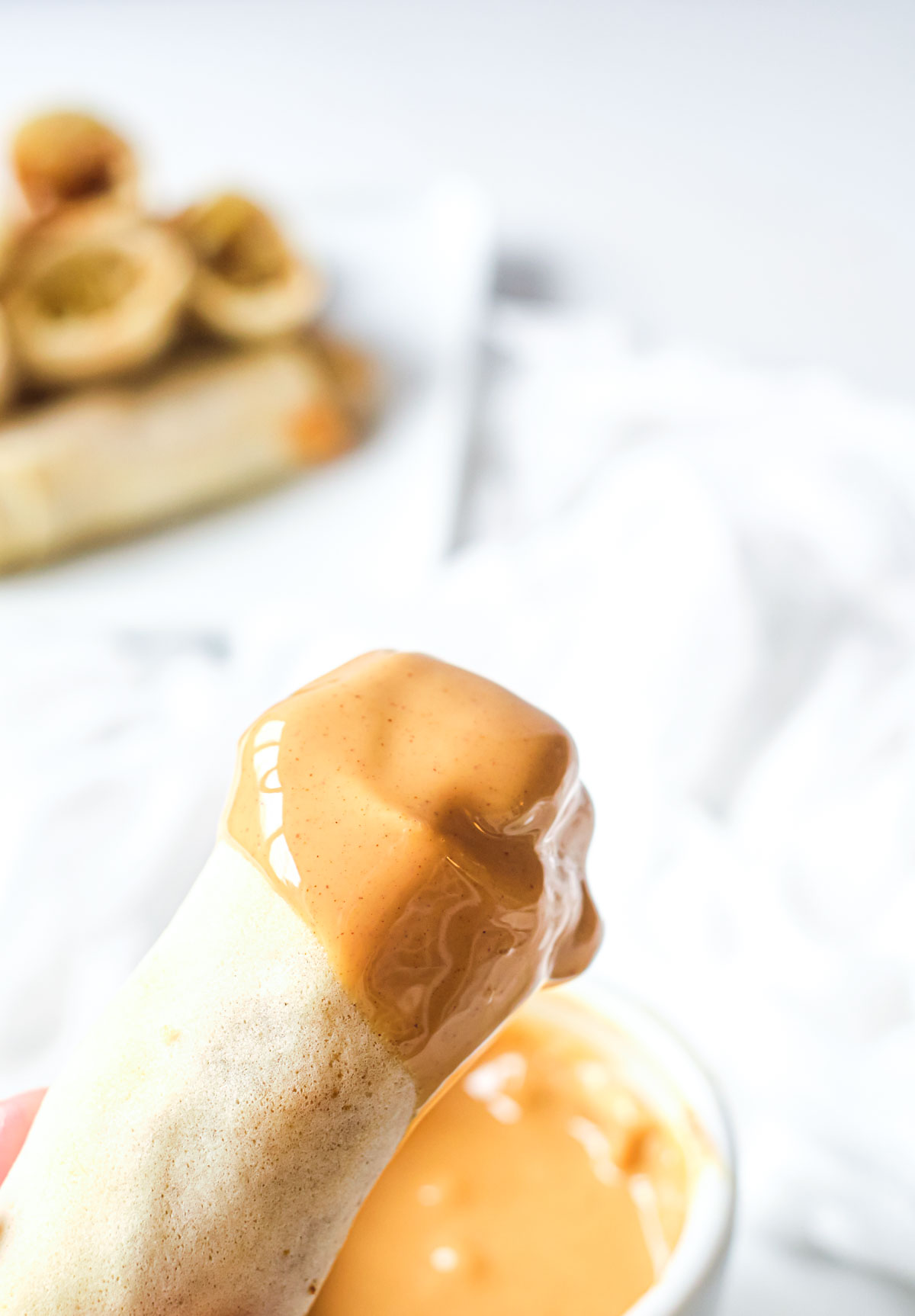 one banana spring roll dipped in melted peanut butter