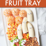 fruit with googly eyes and candy corn on a rectangular tray
