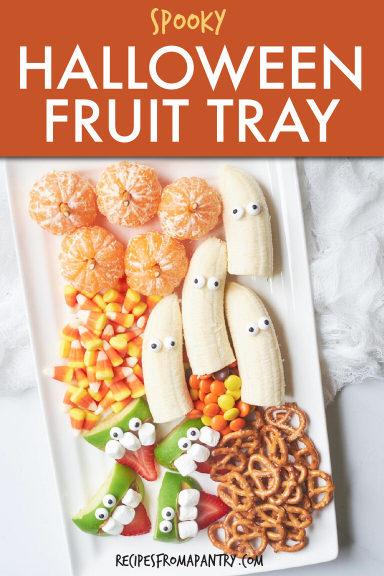fruit with googly eyes and candy corn on a rectangular tray