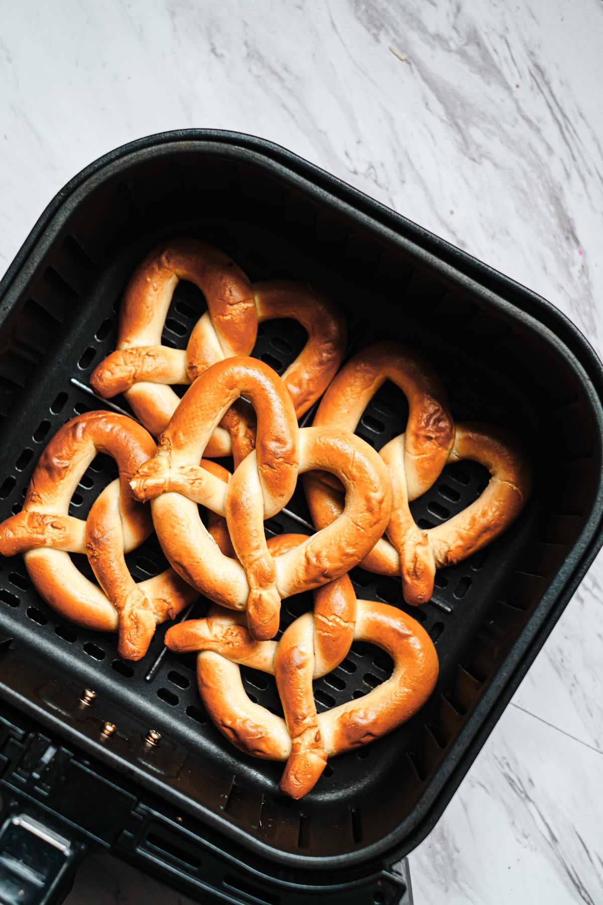 top down view of frozen soft pretzels in air fryer basket