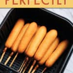 A GROUP OF CORN DOGS IN AN AIR FRYER