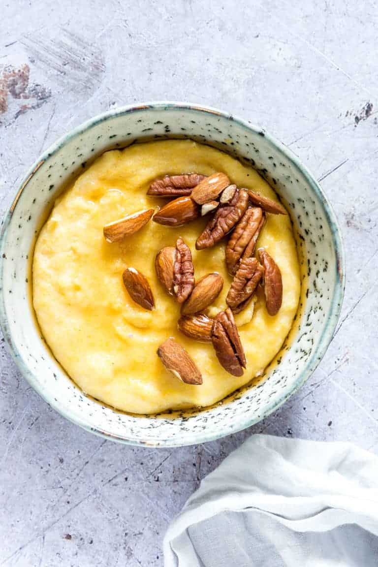 close up of instant pot polenta breakfast porridge topped with nuts