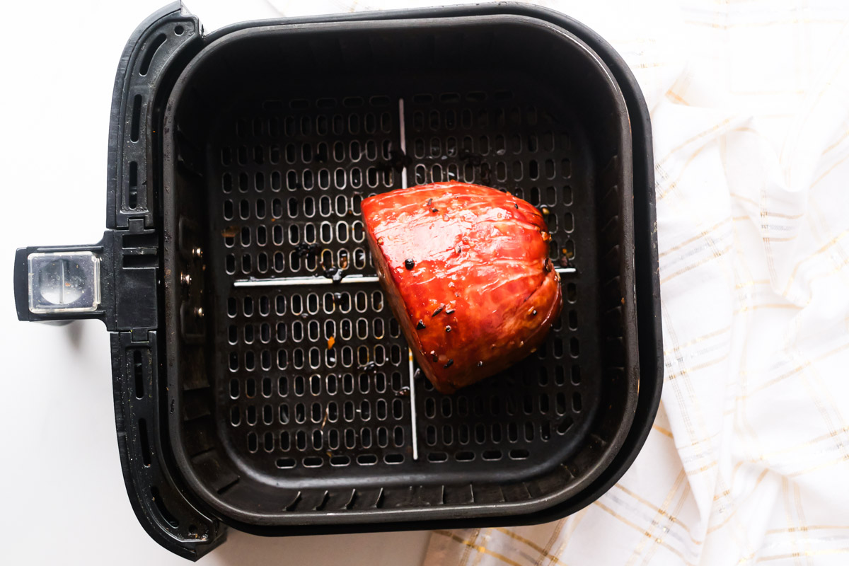 top down view of the cooked air fryer ham inside the air fryer basket