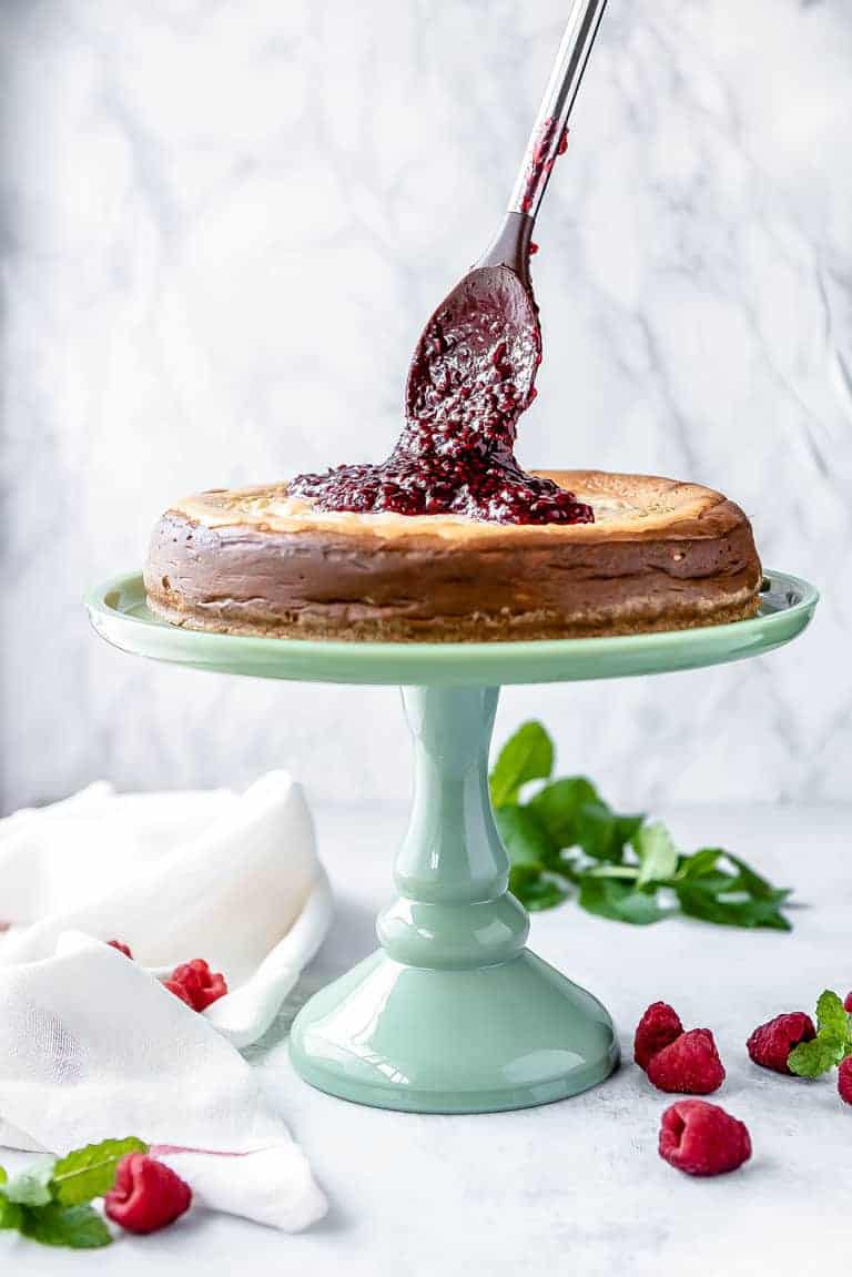 a low carb cheesecake with raspberry jam being added on