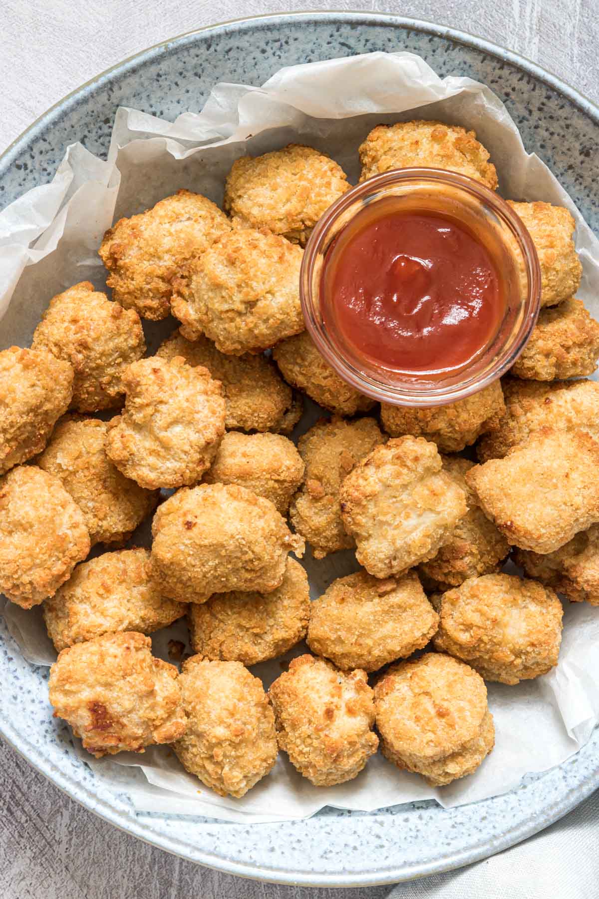 top down view of chicken nuggets in a bowl served with dipping sauce