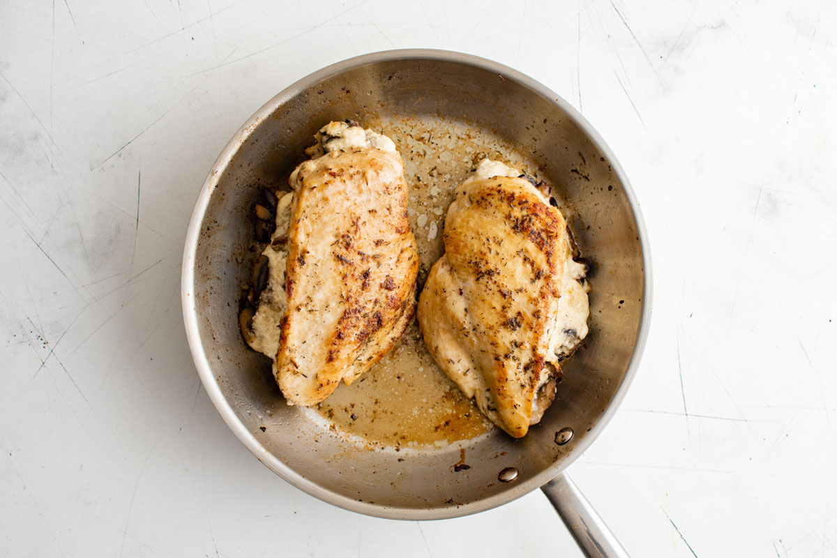top down view of the mushroom stuffed chicken breast in a pan