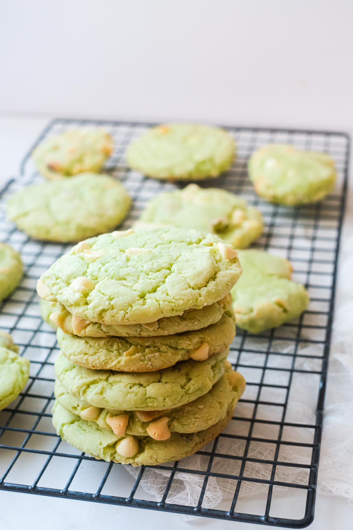 air fryer pistachio pudding cookies on a cooling rack and stacked vertically